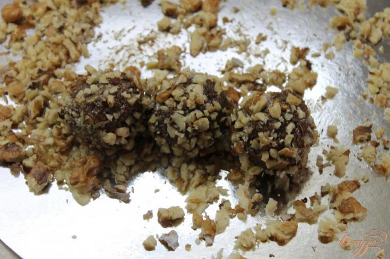 Фото приготовление рецепта: Сладкие шарики из шоколадного бисквита с масляным кремом и орехами шаг №6