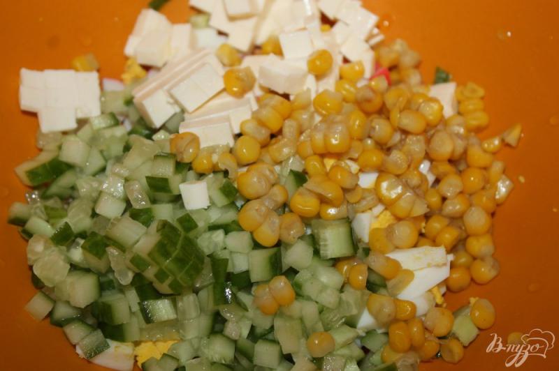 Фото приготовление рецепта: Салат из крабовых палочек, огурца, кукурузы и плавленого сыра шаг №5