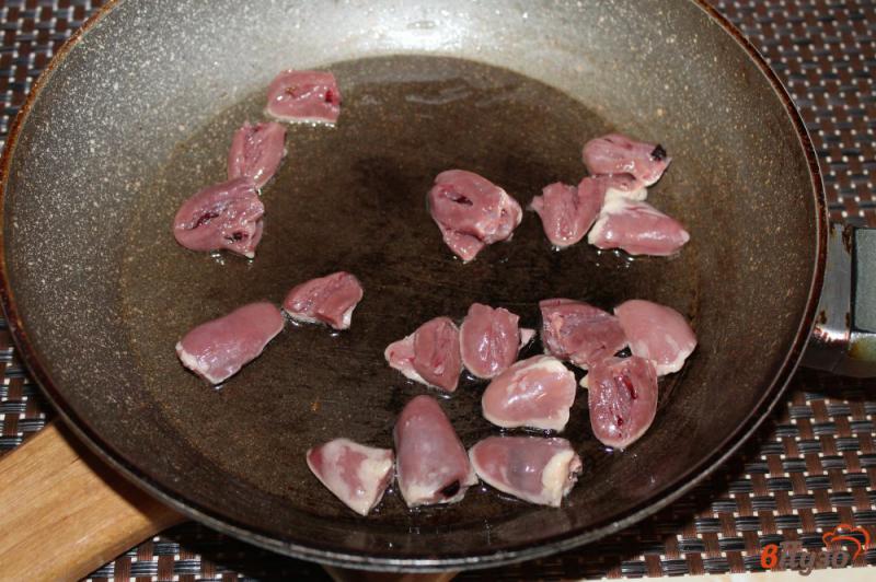 Фото приготовление рецепта: Рис с куриными сердечками и луком шаг №3