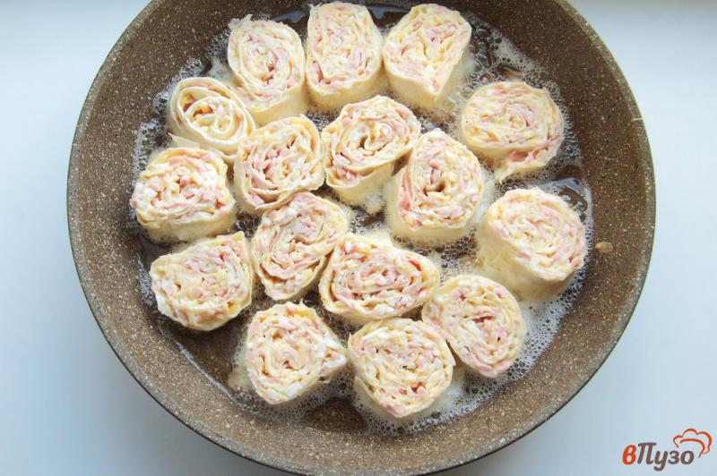 Фото приготовление рецепта: Жареные рулетики из лаваша с колбасой, сыром и яйцами шаг №10