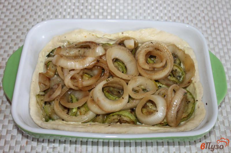 Фото приготовление рецепта: Открытый пирог из слоеного теста с кабачками, луком и сыром шаг №6