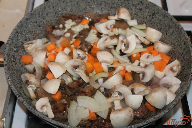 Фото приготовление рецепта: Свиная печень с грибами и морковью в сметанном соусе шаг №4