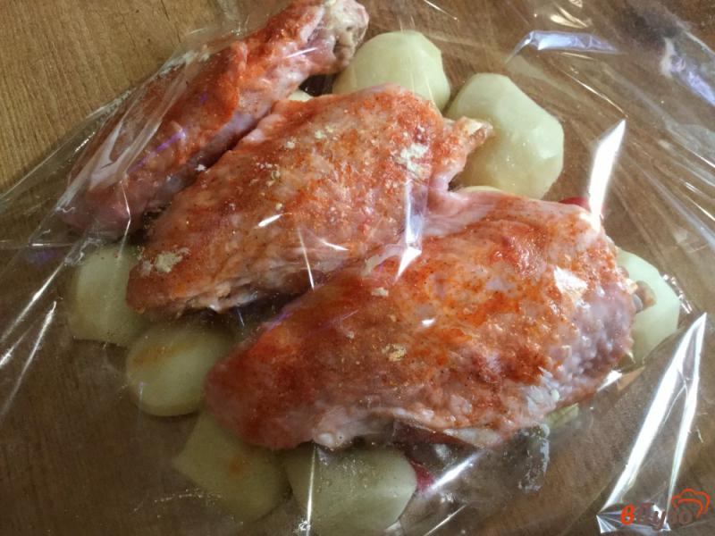 Фото приготовление рецепта: Индюшиные крылья с картофелем и болгарским перцем, запеченные в рукаве шаг №7