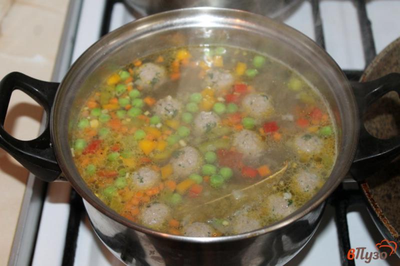 Фото приготовление рецепта: Суп с фрикадельками, цветной капустой и зеленым горошком шаг №7