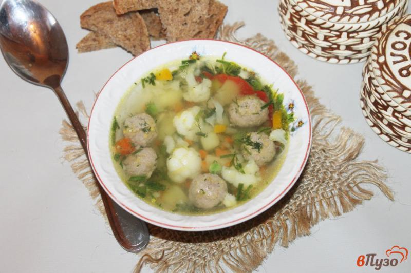 Фото приготовление рецепта: Суп с фрикадельками, цветной капустой и зеленым горошком шаг №8